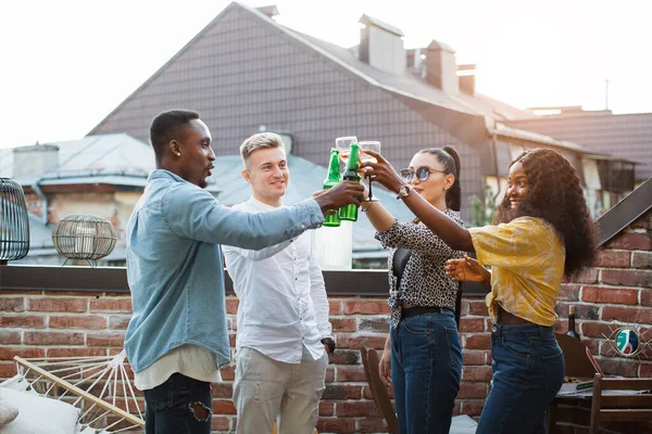 Dört arkadaş partide alkollü içkilerle kadeh kaldırıyor. — Stok fotoğraf