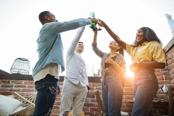 Quatre amis grillent avec des boissons alcoolisées à la fête — Photo