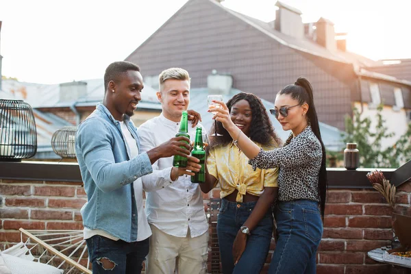 Karışık ırk arkadaşları çatıda alkollü içeceklerin tadını çıkarıyor. — Stok fotoğraf
