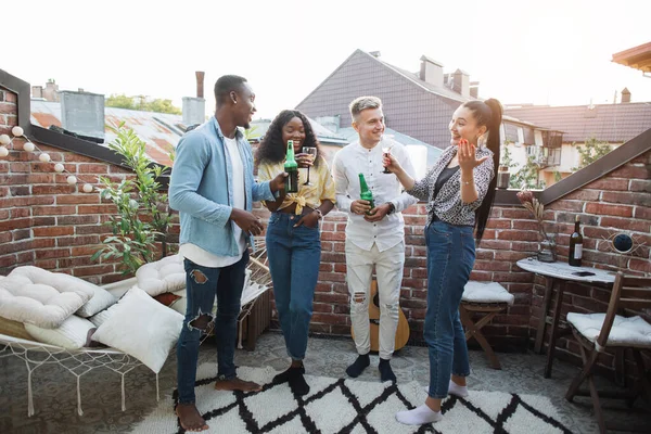 Portrait complet d'amis multiraciaux debout ensemble sur une terrasse ouverte parlant et buvant. Jeunes hipsters élégants faisant la fête pendant les week-ends — Photo