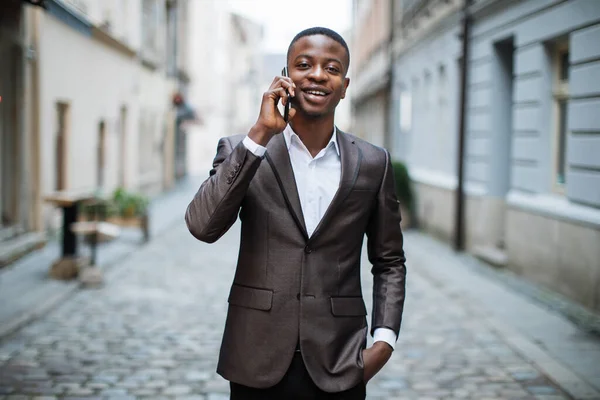 Afrikaanse man in pak in gesprek op mobiele — Stockfoto