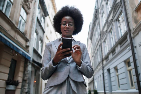 Afrikaanse zakenvrouw met smartphone op straat — Stockfoto