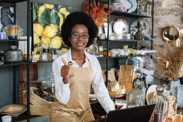 Афроамериканська продавниця показуючи великий палець вгору і посміхаючись — стокове фото