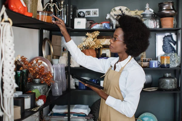 Attrayant vendeur femelle vérifier décor avec tablette à la boutique — Photo