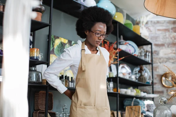 Африканська американка в бежевому фартусі в магазині декору. — стокове фото