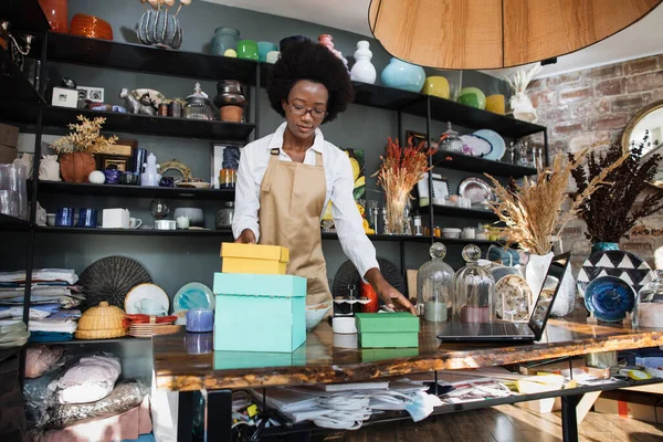 Afro américaine vendeuse boîtes d'emballage en magasin — Photo