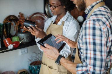 Dükkanda iki farklı tabletli insan mal alıyor.