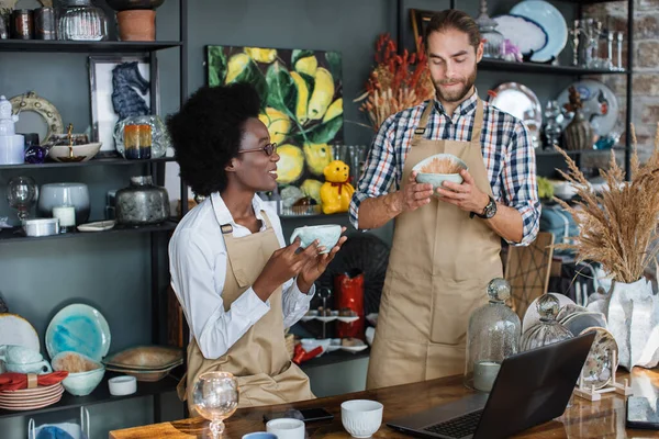 Divers employés de magasin utilisant un ordinateur portable pour raconter toutes les marchandises — Photo