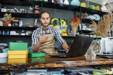 Satış elemanı kayıt indirimi kartı olarak dizüstü bilgisayar kullanıyor.