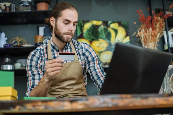 Satış elemanı kayıt indirimi kartı olarak dizüstü bilgisayar kullanıyor.