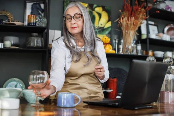 Pretty aged woman rechecking assortment at store — Stock Photo, Image