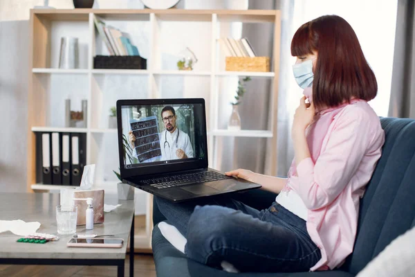 stock image Laptop monitor view over woman shoulder, girl in headphones listens female therapist, medic gives recommendation how protect people during corona virus ncov epidemic outbreak pandemic disease concept