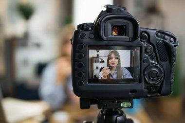 Çekici kadın kozmetik hakkında video dersi kaydediyor.
