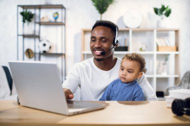 Evinde dizlerinin üzerinde dizlerinin üzerinde çalışan Afrikalı bir adam.