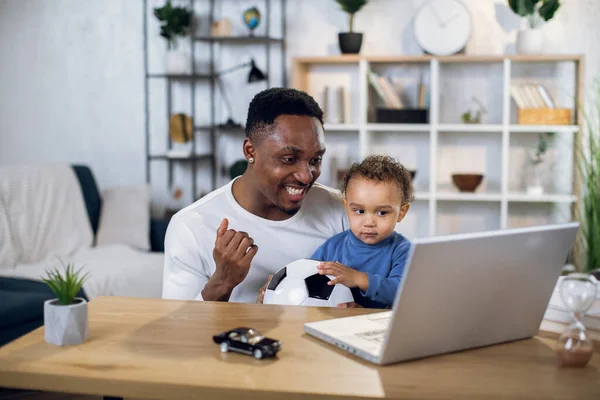 Africano padre e hijo viendo partido de fútbol en el ordenador portátil — Foto de Stock