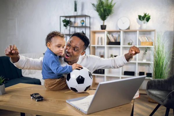 Feliz padre africano y su hijo viendo fútbol en el portátil — Foto de Stock