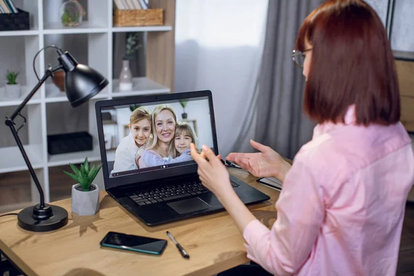 Bilgisayardan ailesiyle görüntülü konuşma yapan bir kadın.