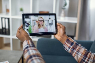 Öğrenci, öğretmeniyle tablette video görüşmesi yapıyor.