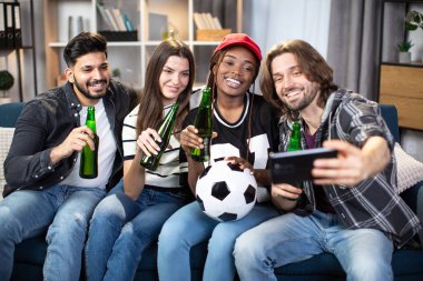 Arkadaşlar futbol maçı izlerken selfie çekiyorlar.