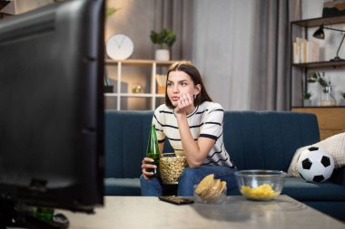 Kadın taraftar TV 'de maç izliyor.