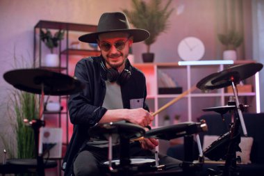 Karanlık stüdyoda davul çalan ilham verici bir adam.