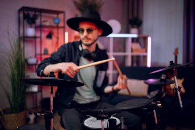 Erkek müzisyen stüdyoda elektronik davullarda prova yapıyor.