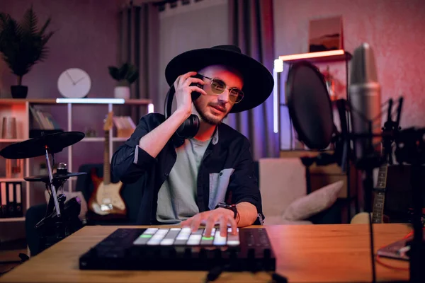 Man creating music using dj controller and headphones