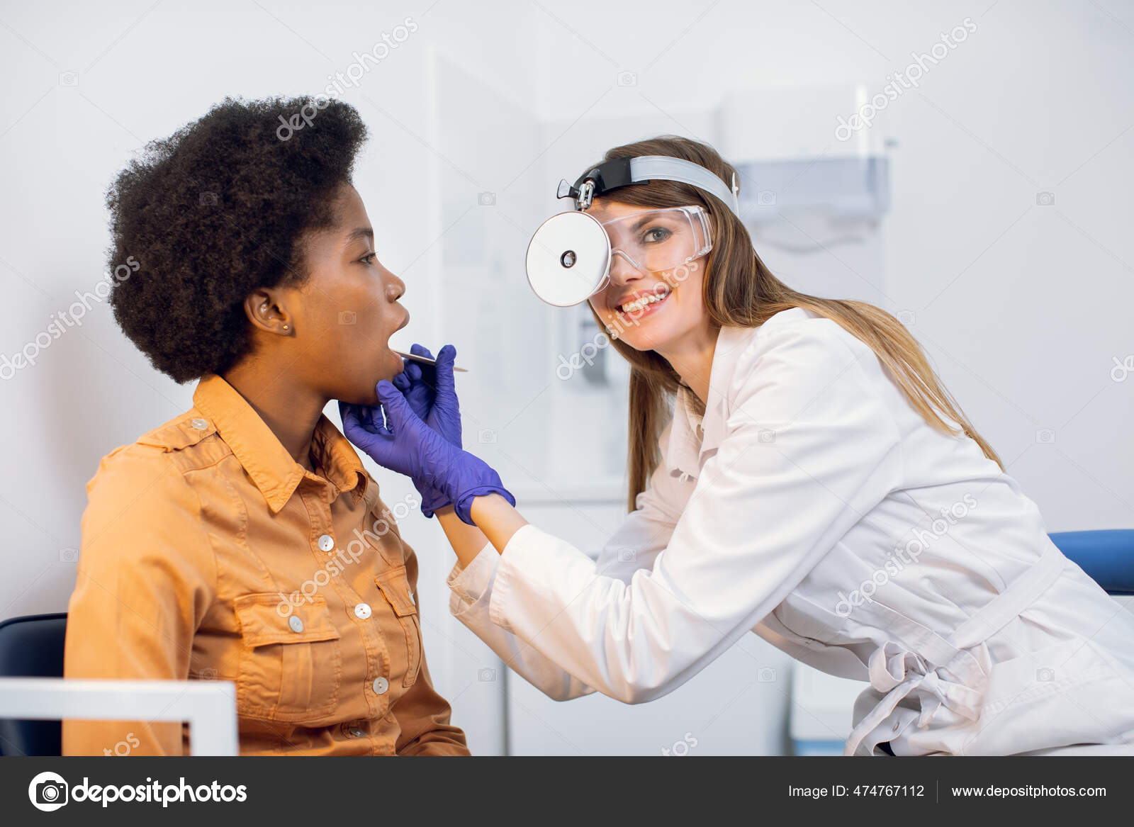 Joven mujer caucásica atractiva que recibe un examen médico del oído en una  clínica moderna. Profesional femenino que examina el oído del paciente,  usando un otoscopio, en el consultorio del médico Fotografía