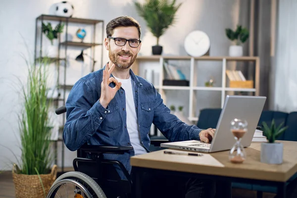 Sorrindo cara com deficiência trabalhando no laptop em casa — Fotografia de Stock