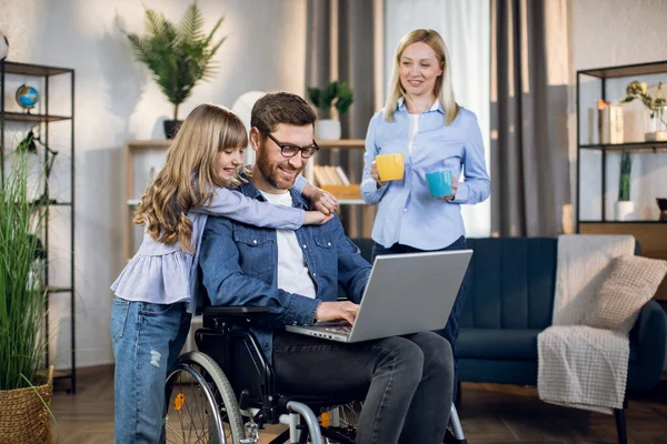 Hombre en silla de ruedas con familia en casa — Foto de Stock