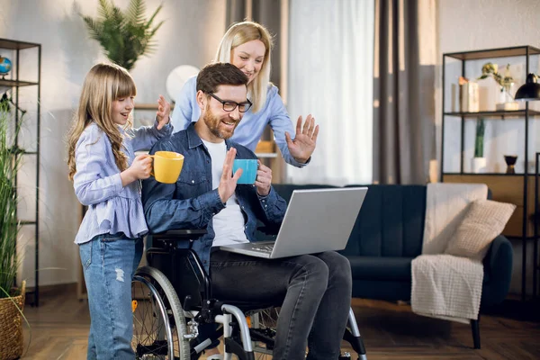 Γυναίκα και παιδί στέκεται κοντά άνθρωπος σε αναπηρική καρέκλα με φορητό υπολογιστή — Φωτογραφία Αρχείου