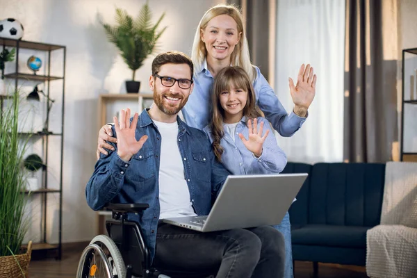 Esposa con hija apoyando marido en silla de ruedas — Foto de Stock