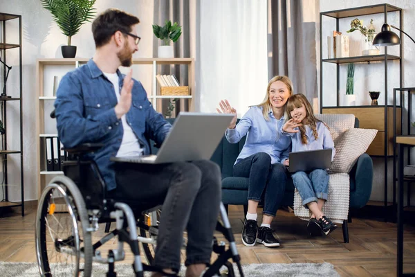 Gehandicapte man en zijn gezin met behulp van laptops thuis — Stockfoto