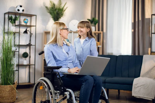 Γυναίκα σε αναπηρική καρέκλα με φορητό υπολογιστή και μιλώντας με την κόρη — Φωτογραφία Αρχείου