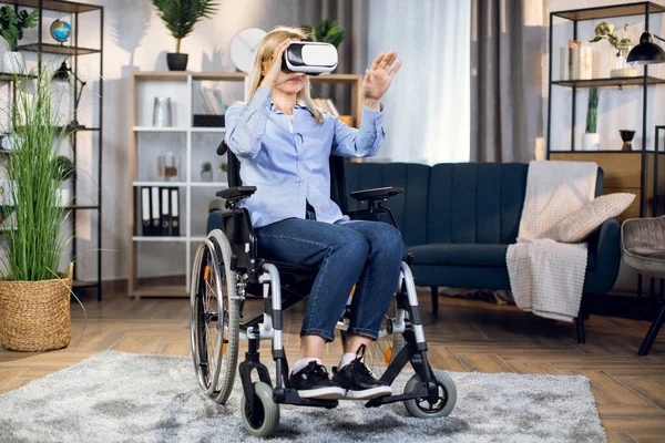 Vrouw in rolstoel draagt thuis een virtuele bril — Stockfoto