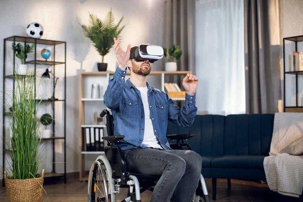 Νεαρός που κάθεται σε αναπηρική καρέκλα και φοράει γυαλιά εικονικής πραγματικότητας — Φωτογραφία Αρχείου