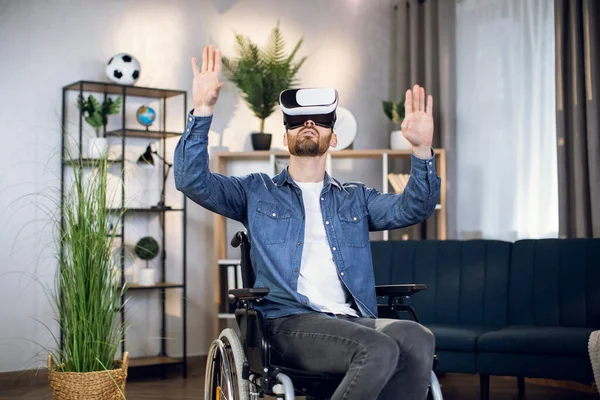 Bearded guy with special needs using virtual headset at home