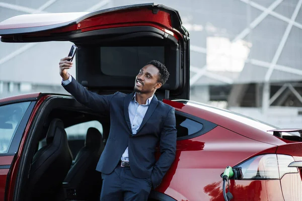 Ο άνθρωπος που χρησιμοποιεί το κινητό για την κλήση βίντεο κατά τη φόρτιση auto — Φωτογραφία Αρχείου