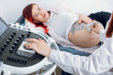 Klinikte kadın doktorun ultrason cihazını kullanırken yakın plan çekimleri hamile kadın hasta için ultrason yapar. Ultrason tarayıcısı. Sonografi. Makine düğmelerine odaklan.