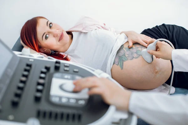 Imagen de cerca recortada del obstetra médico femenino, pulsando botones en un panel de control que realiza un procedimiento de ecografía para la mujer embarazada. Concéntrate en una mujer embarazada. —  Fotos de Stock