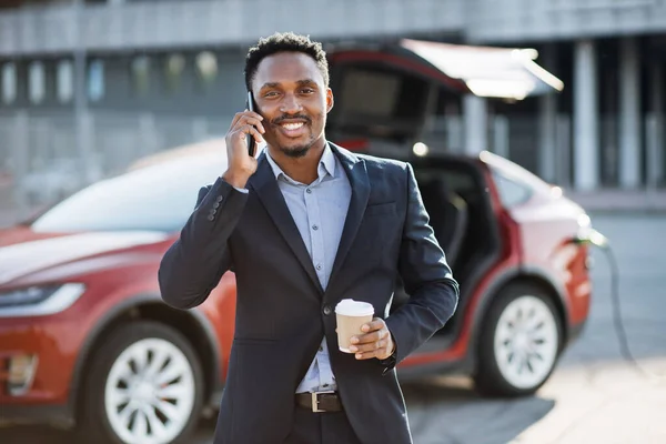 Homme ayant conversation mobile en attendant voiture électrique — Photo