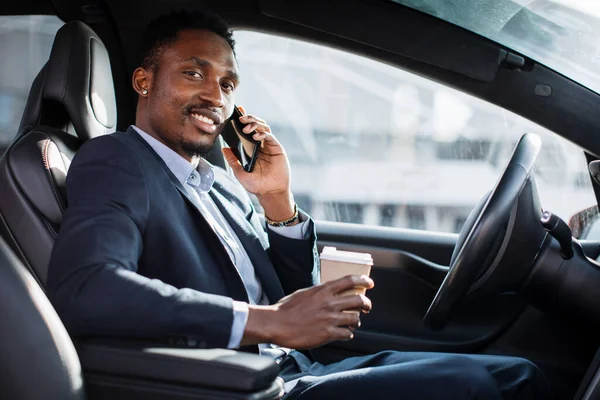Pengusaha Afrika memiliki percakapan mobile sambil duduk di dalam mobil — Stok Foto