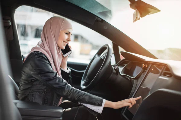 Mulher tocando painel enquanto fala no celular no carro — Fotografia de Stock