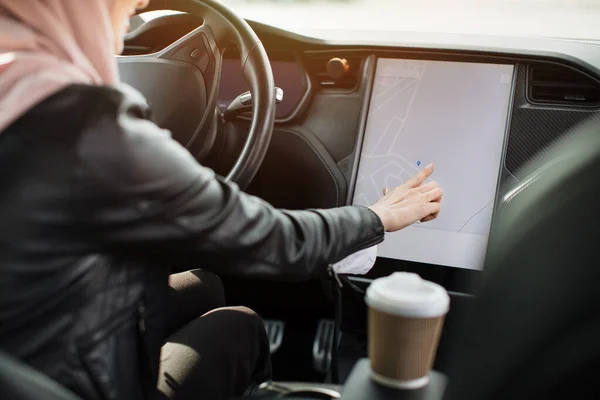 Arabe femme assise dans la voiture et en utilisant le tableau de bord électronique — Photo