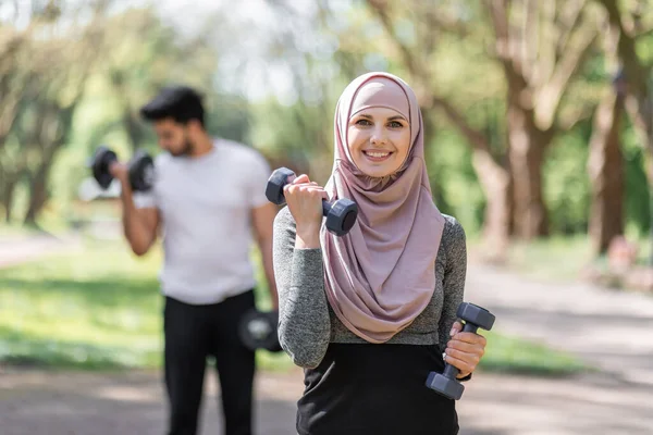 Mujer en hijab y musulmán chico entrenamiento con mancuernas — Foto de Stock