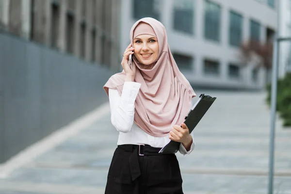 Muszlim üzletasszony beszél mobilon az utcán — Stock Fotó