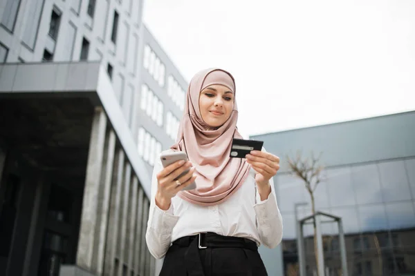 Muslimische Frau beim Einkaufen mit Kreditkarte und Handy — Stockfoto