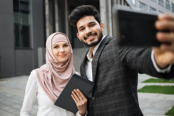 Muslimische Männer und Frauen in offizieller Kleidung machen Selfie mit dem Handy — Stockfoto