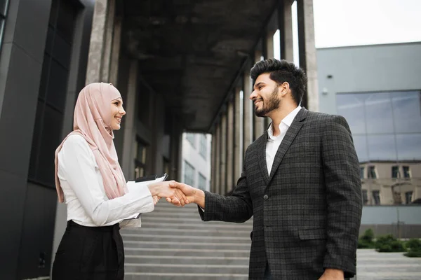 Frau im Hijab und muslimischer Mann beim Händeschütteln im Freien — Stockfoto