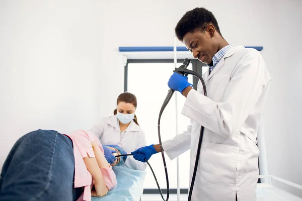 Africano homem médico e enfermeira fazendo procedimento de endoscopia para paciente do sexo feminino na clínica — Fotografia de Stock